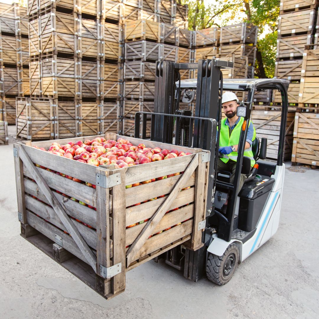 forklift moving crate of apples